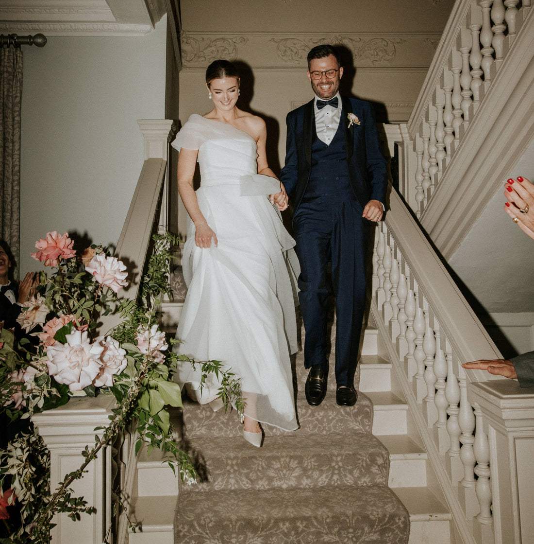 Couple Walking Down Stairs Wearing Bridal Attire