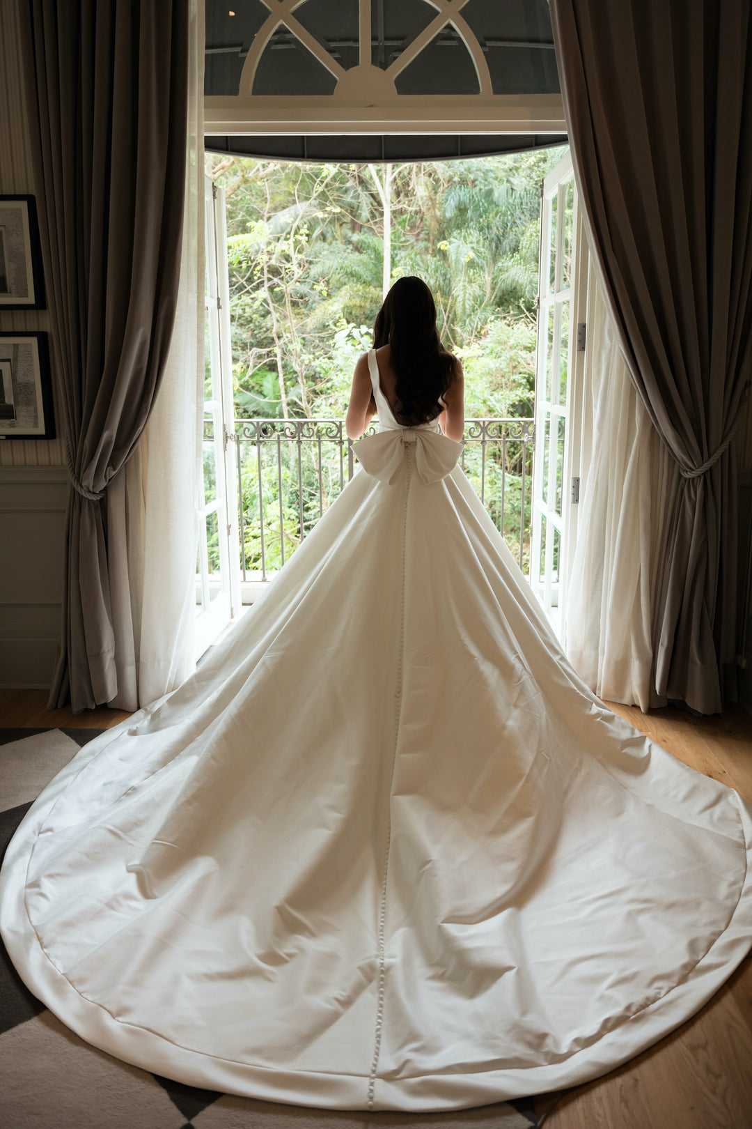 A view of the long rounded train behind the back of the dress, beginning from the under the bow