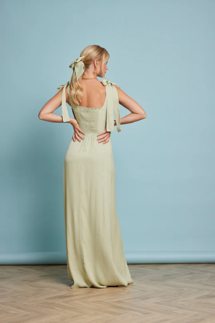 Back Profile of Model Wearing Allegra Sage Green Wedding Guest Dress