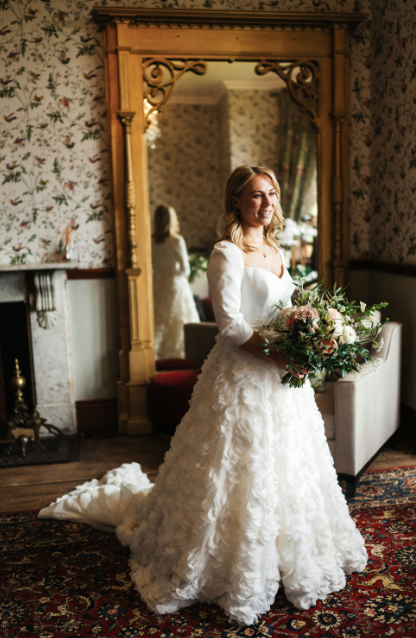 A Queen Anne corseted bodice and 3D chiffon appliqué skirt create a silhouette that's both regal and romantic