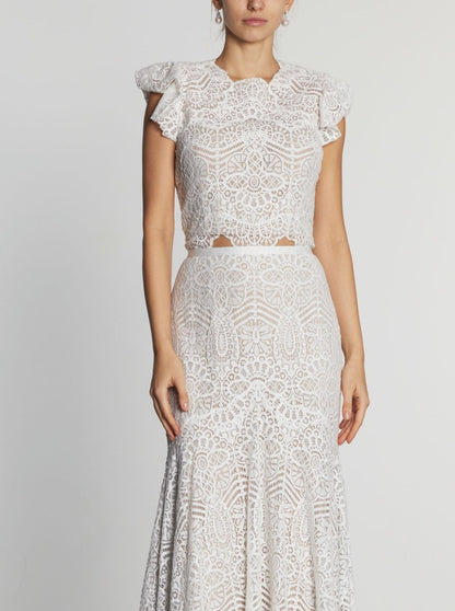 This two-piece lace ensemble features Aspen lace, chic ruffle sleeves, a captivating open back, and a fluted skirt with train